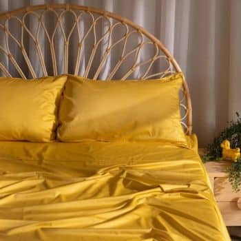yellow bed linen on the bed with two pillows
