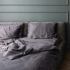 Stylish bedroom with unmade bed near cupboard